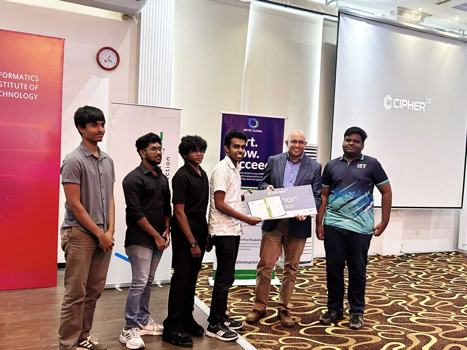 A BISTEC Global judge presenting a Cipher 2.0 certificate to a student team at IIT